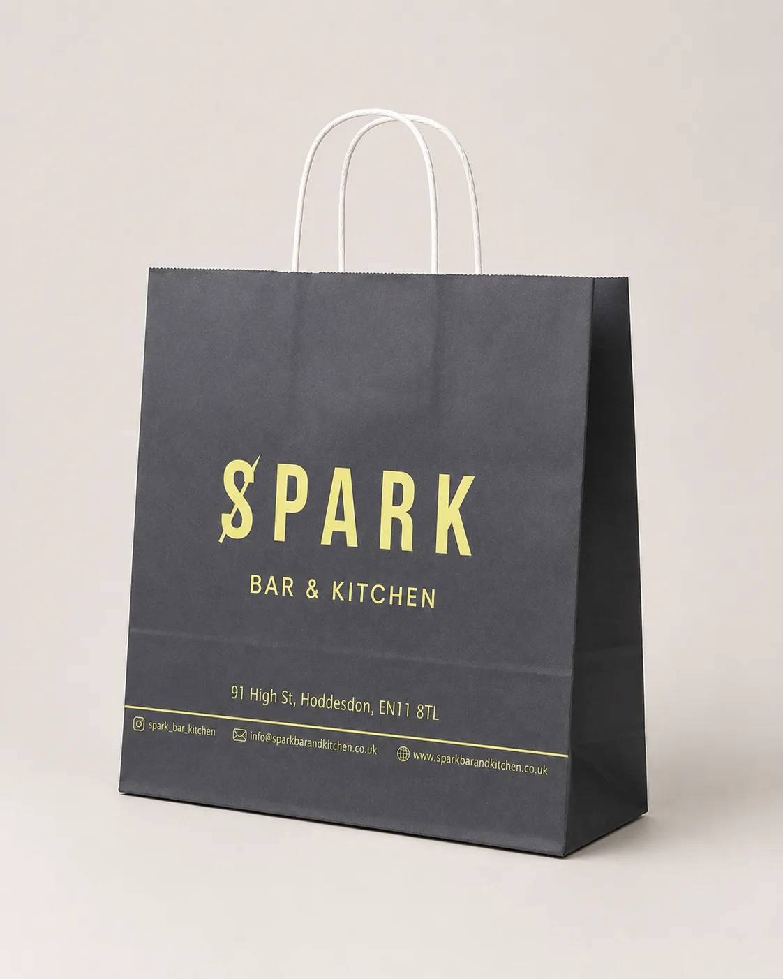 Antrasit gövdeli, sarı baskılı, burgulu beyaz saplı Spark Bar & Kitchen kağıt çantası