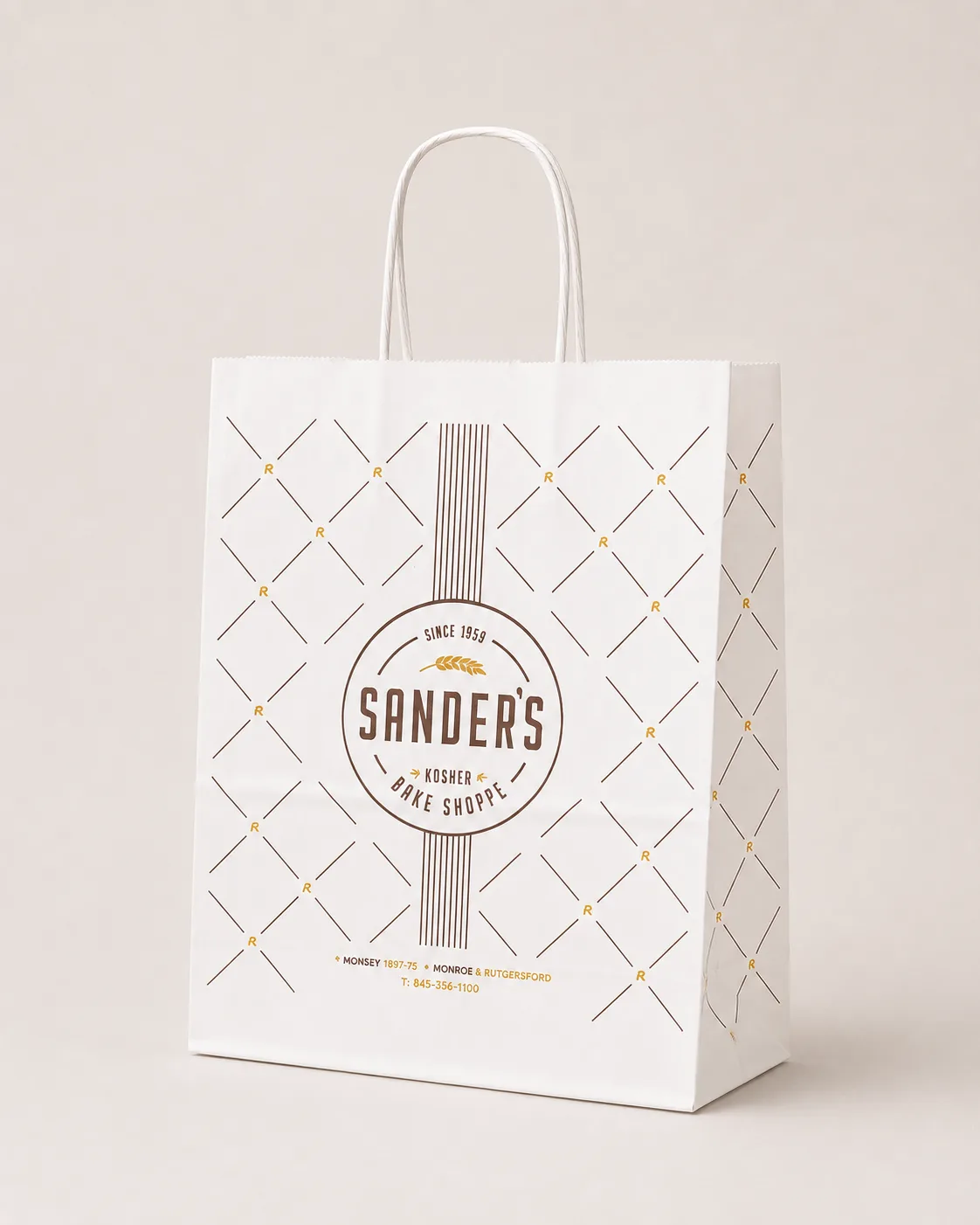 Beyaz gövdeli, kahve ve altın renkte baklava desenli baskısı olan, burgulu beyaz saplı Sander's Kosher Bake Shoppe kağıt çantası